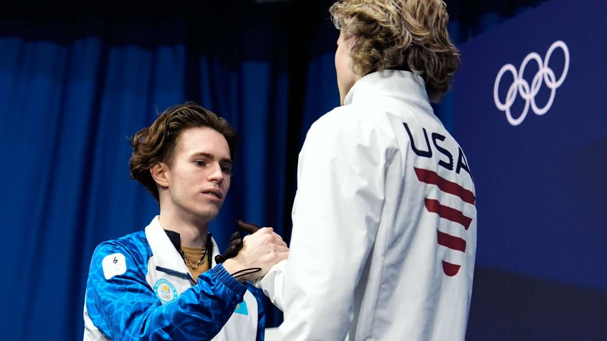 Mikhail Shaidorov of Kazakhstan reacts to seeing that he took the gold while greeting Ilia Malinin of the United States during the men's free skate program in figure skating at the 2026 Winter Olympics, in Milan, Feb. 13.