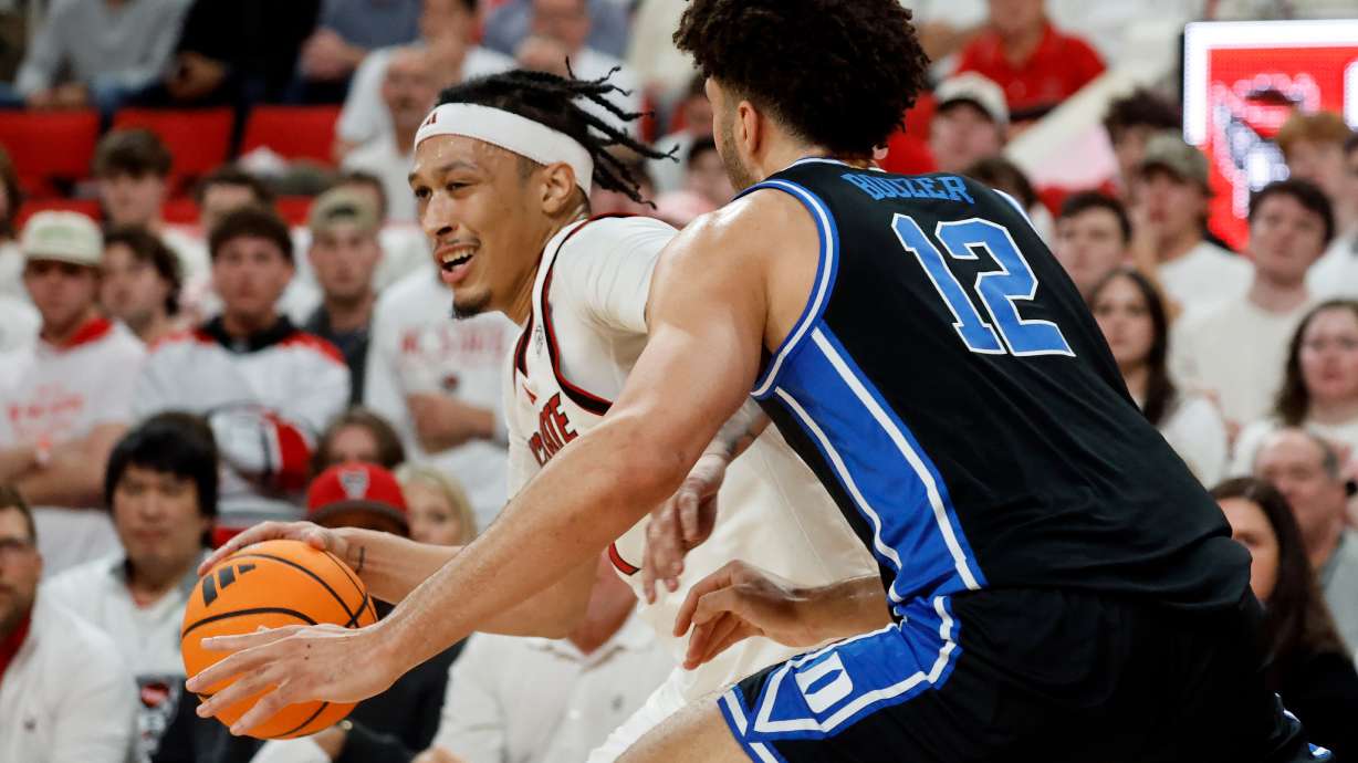 North Carolina State's Darrion Williams, left, tries to drive the ball around Duke's Cameron Boozer (12) during the first half of an NCAA college basketball game in Raleigh, N.C., Monday, March 2, 2026.