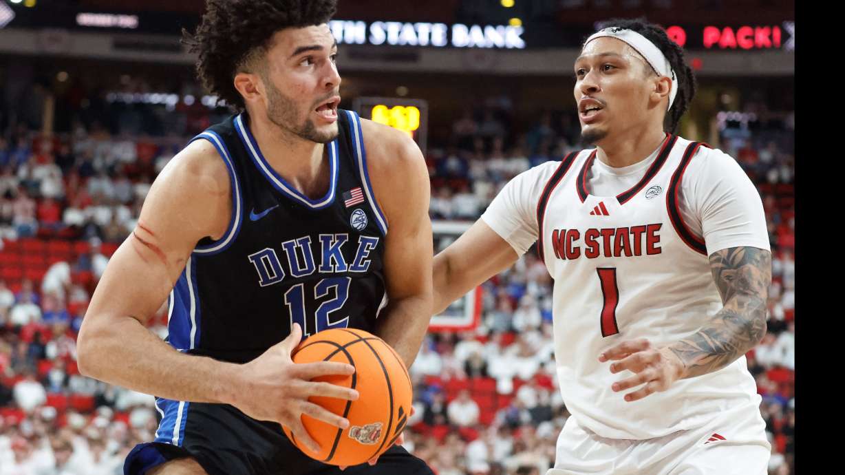 Duke's Cameron Boozer (12) drives the ball past North Carolina State's Darrion Williams (1) during the second half of an NCAA college basketball game in Raleigh, N.C., Monday, March 2, 2026.