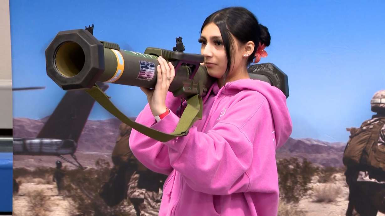 Emilynn Cota holds one of the props at a booth during Ben Lomond High School's aerospace career fair, Tuesday. Dozens of companies filled the school's athletic center to show what opportunities exist in engineering, manufacturing, and advanced technology.
