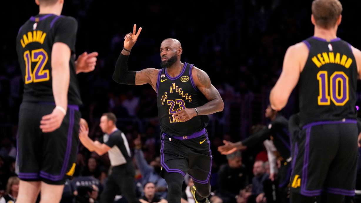 Los Angeles Lakers forward LeBron James, center, gestures after scoring as Los Angeles Lakers forward Jake LaRavia, left, and guard Luke Kennard watch during the first half of an NBA basketball game Tuesday, March 3, 2026, in Los Angeles.