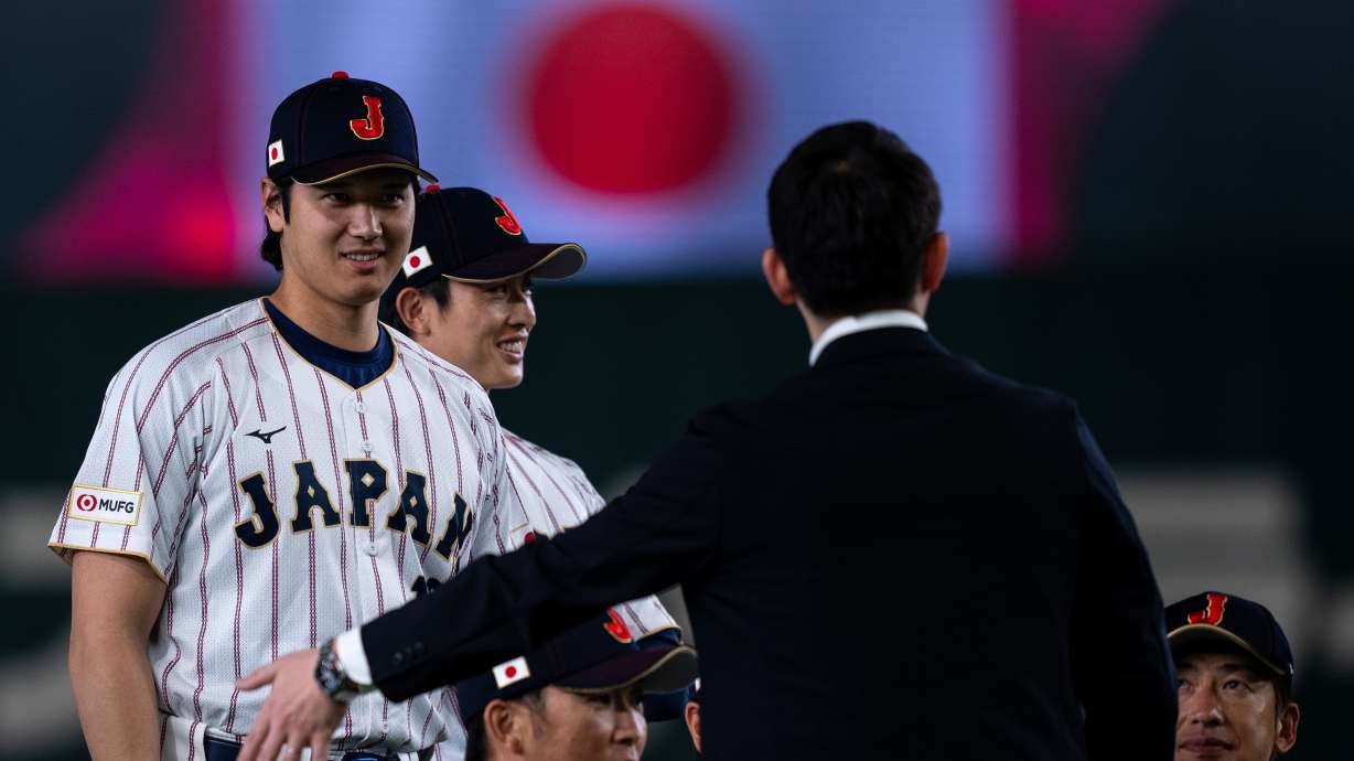 Japan's Shohei Ohtani, left, stands during a group photo session along with other team members before their practice session ahead of the World Baseball Classic games in Tokyo, Wednesday, March 4, 2026.