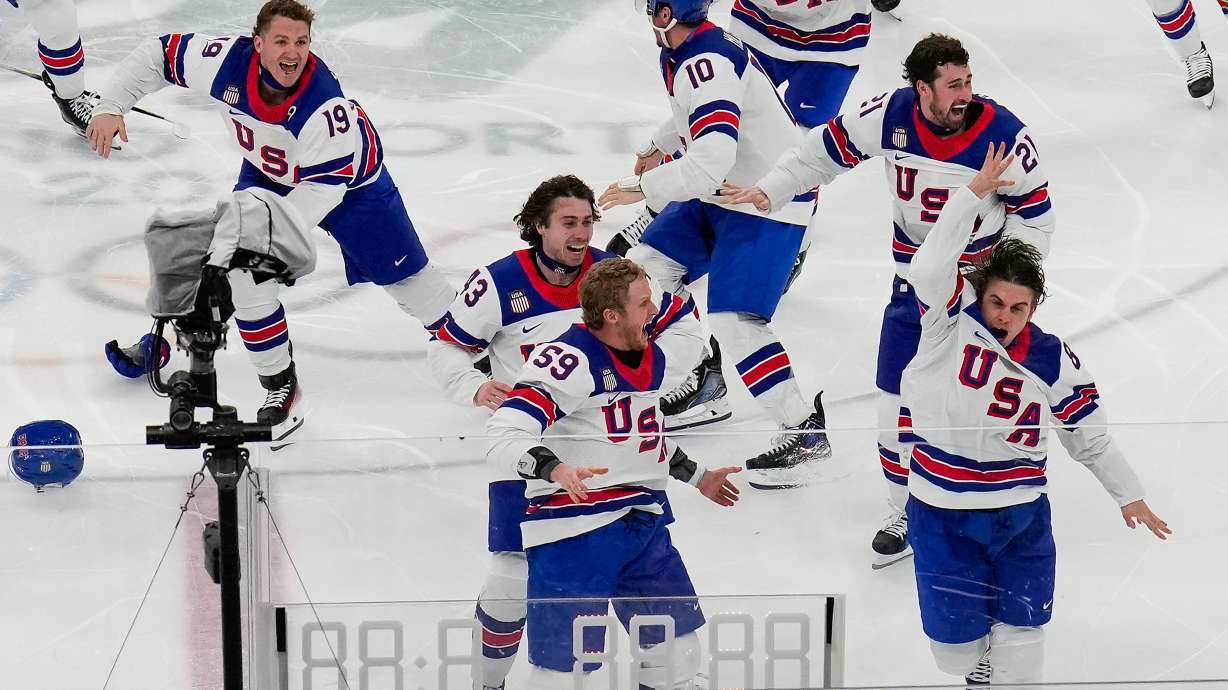 United States' Jack Hughes (86), right, celebrates with teammates after scoring the game winning goal against Canada in sudden death overtime during the men's ice hockey gold medal game at the 2026 Winter Olympics, in Milan, Italy, Sunday, Feb. 22, 2026.
