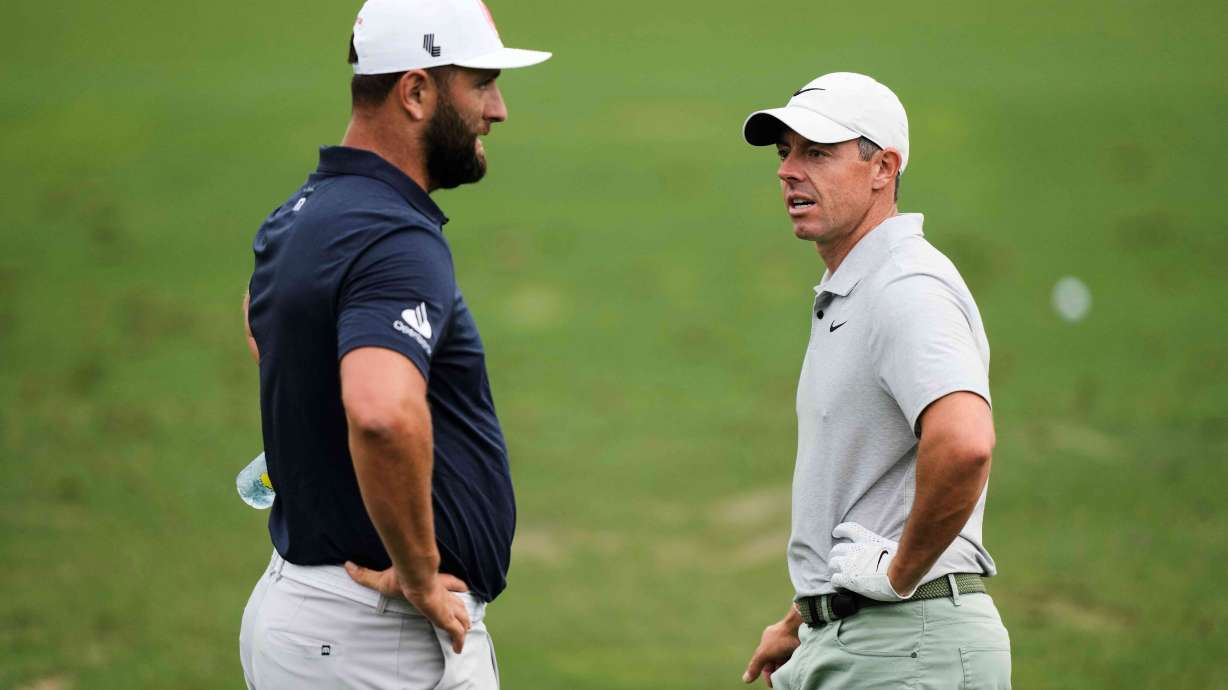 FILE - Jon Rahm, left, of Spain, talks with Rory McIlroy, of Northern Ireland, on the practice range during a practice round in preparation for the Masters golf tournament at Augusta National Golf Club Tuesday, April 9, 2024, in Augusta, Ga.
