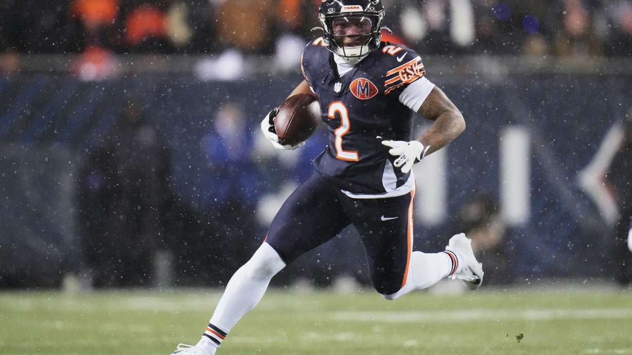 FILE - Chicago Bears wide receiver DJ Moore runs after making a catch against the Los Angeles Rams during the first half of an NFL football divisional playoff game, Jan. 18, 2026, in Chicago.