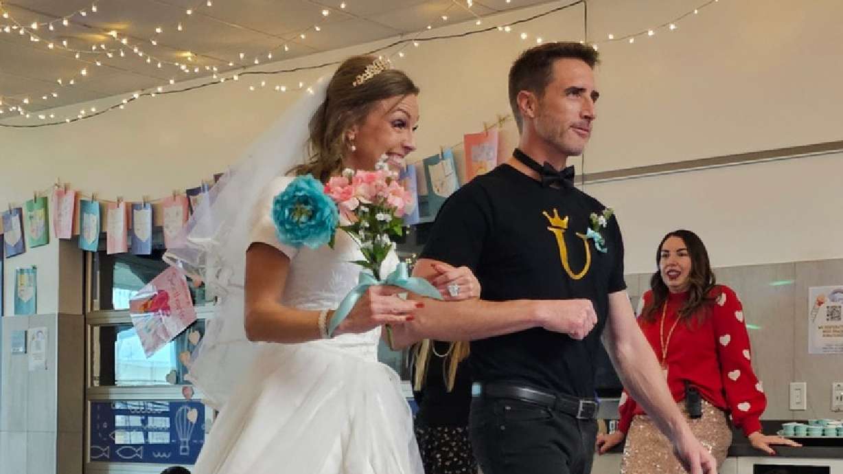 Island View Elementary teacher Teisha Langford walks the aisle with her husband Scott Langford in a "Q-U" wedding to teach students the "qua" sound.