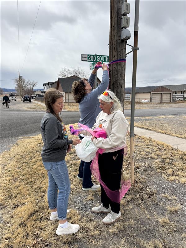 Mary Sorenson, Lori Chappell, and Melissa Robins tie pink ribbons in Lyman, Wayne County, Thursday. The ribbons are to remember three women police say were killed by a stranger.