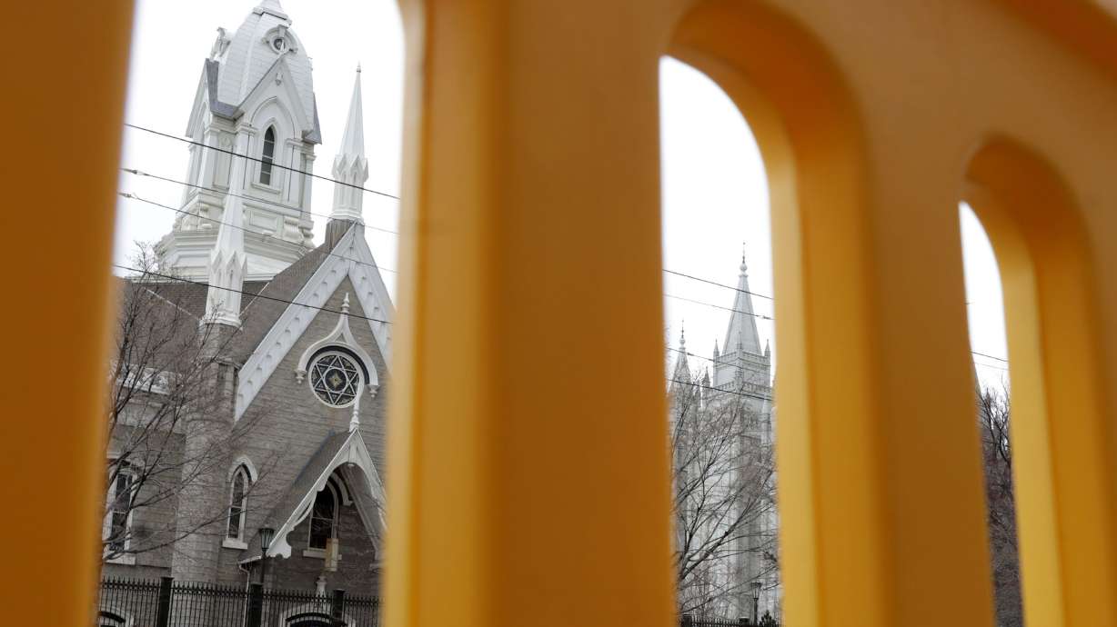 A construction barrier and Temple Square are pictured in Salt Lake City on Thursday. The Salt Lake City Council is considering an ordinance that would temporarily close a few downtown road segments for "public safety and crowd management" from April to October in 2027 due to the reopening of the Salt Lake Temple.