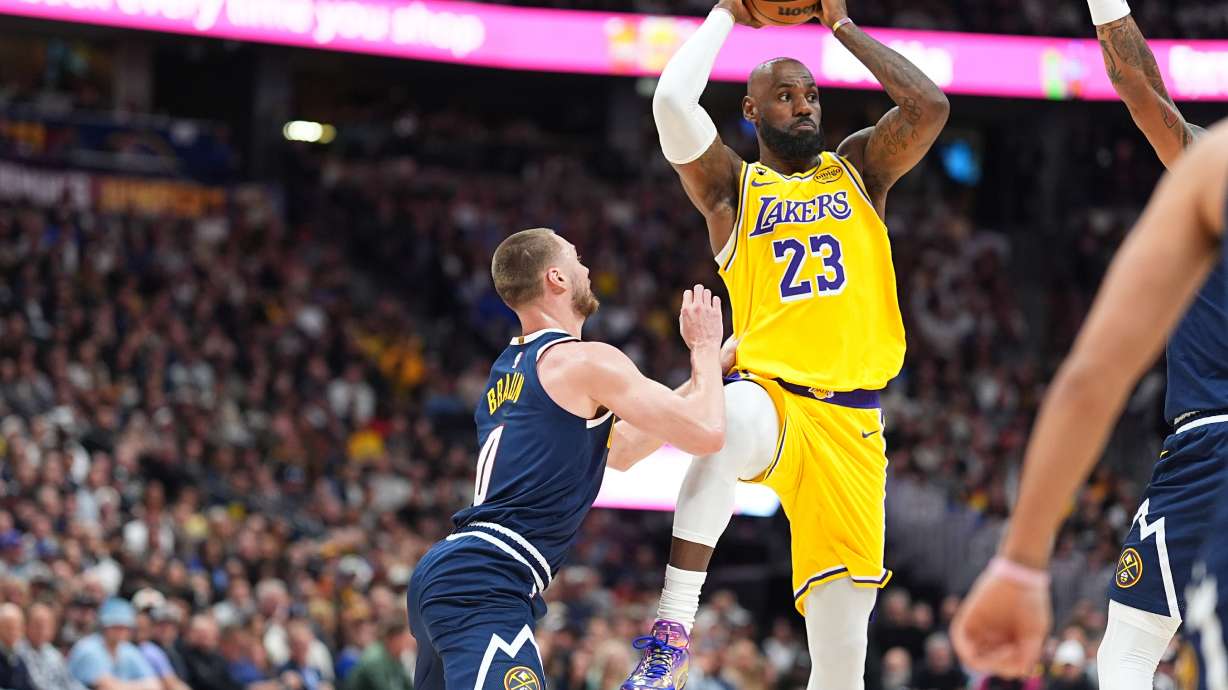 Los Angeles Lakers forward LeBron James, right, passes the ball as Denver Nuggets guard Christian Braun defends in the first half of an NBA basketball game, Thursday, March 5, 2026, in Denver.