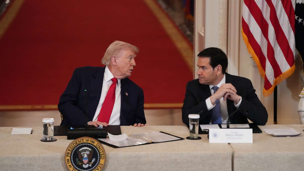 President Donald Trump speaks with Secretary of State Marco Rubio during a roundtable discussion on college sports in the East Room of the White House, Friday, March 6, 2026, in Washington.