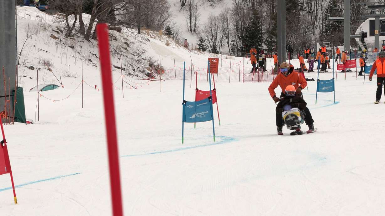 An instructor with Ogden Valley Adaptive guides a client on a sit-ski, Friday. Executive Director Brandon Flint said the organization works to help people with disabilities get out and get active year-round.