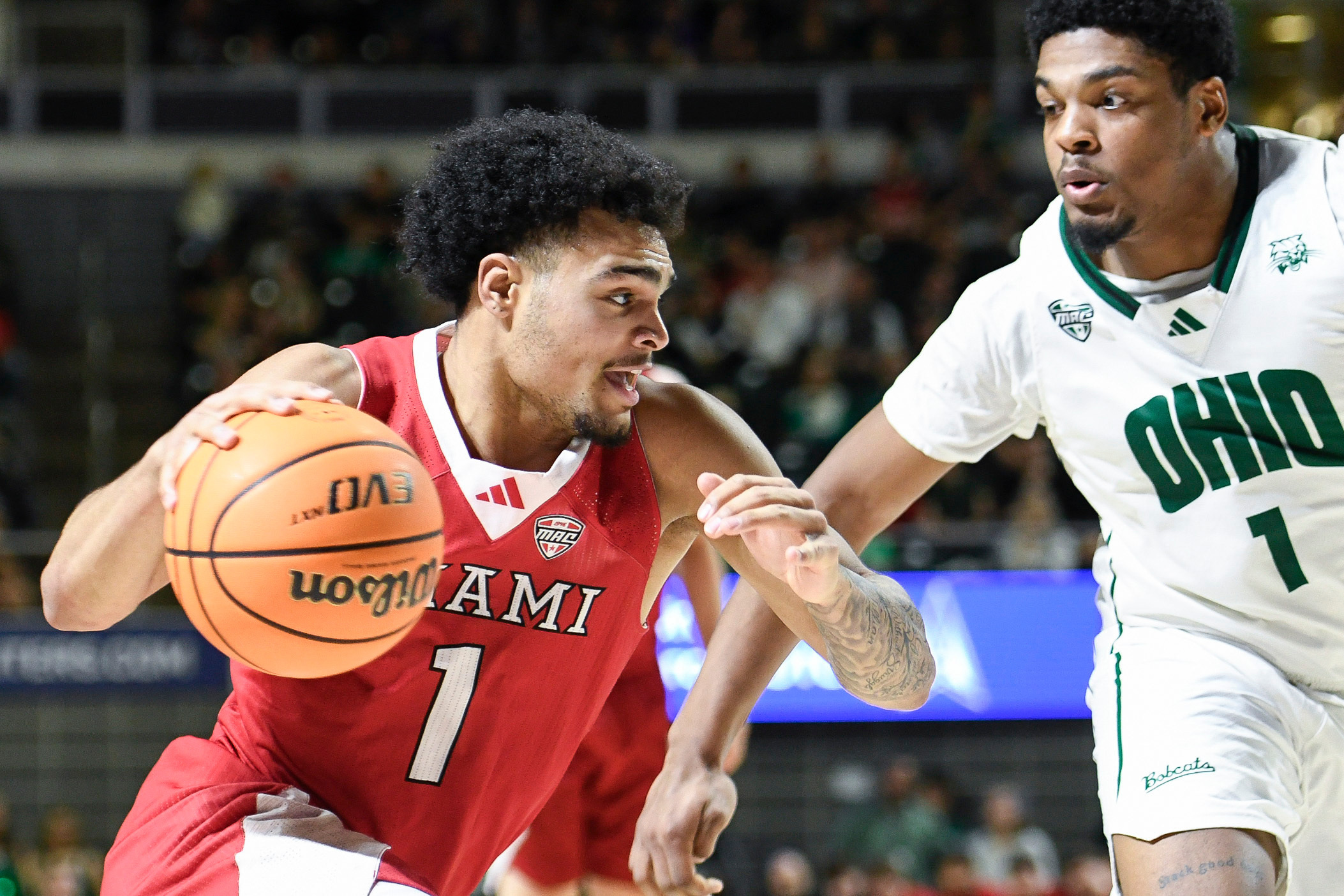 Miami (Ohio) guard Trey Perry (1) drives past Ohio forward Javan Simmons (1) during the first half of an NCAA college basketball game, Friday, March 6, 2026, in Athens, Ohio.