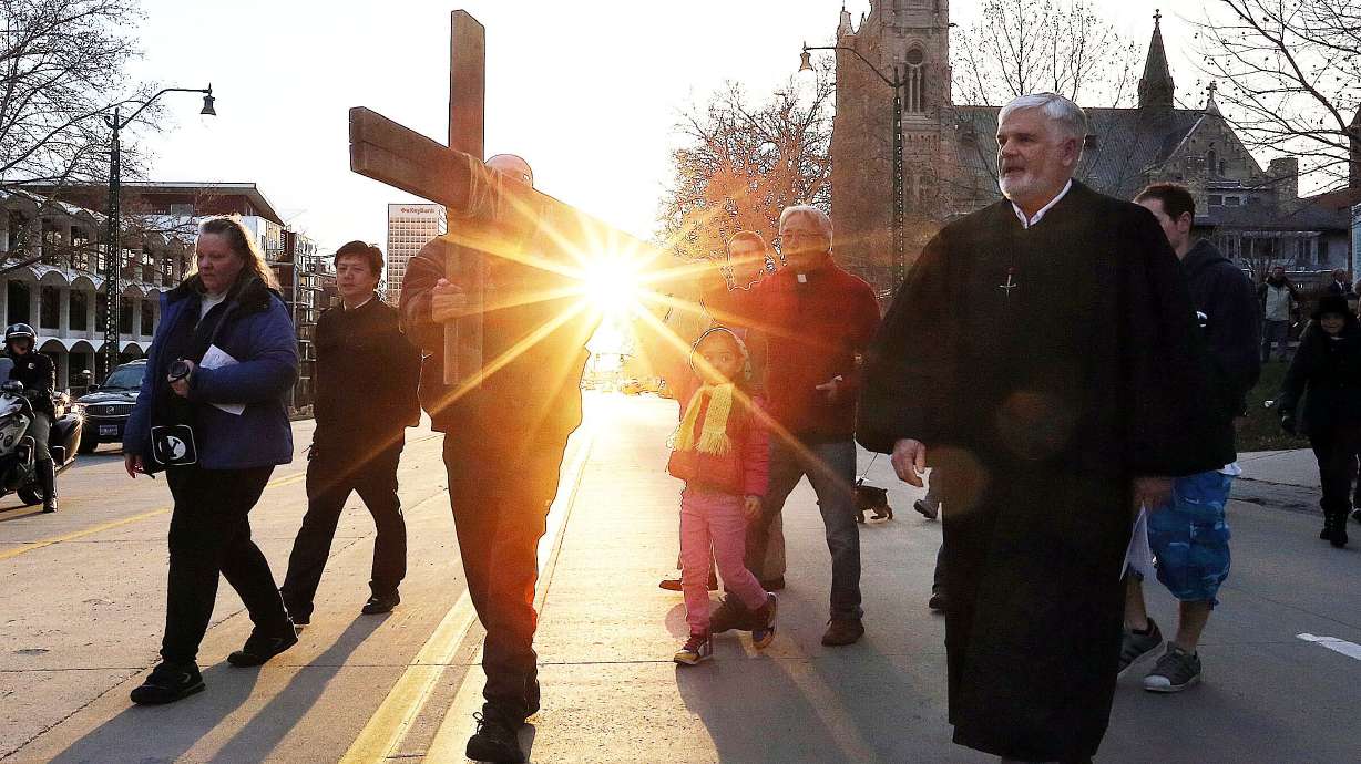 Alex Bury, left, Juliana Snow and the Rev. Eun-sang Lee of the First United Methodist Church carry the cross as it leaves the First Presbyterian Church during the Good Friday Procession of the Cross in Salt Lake City, March 25, 2016.