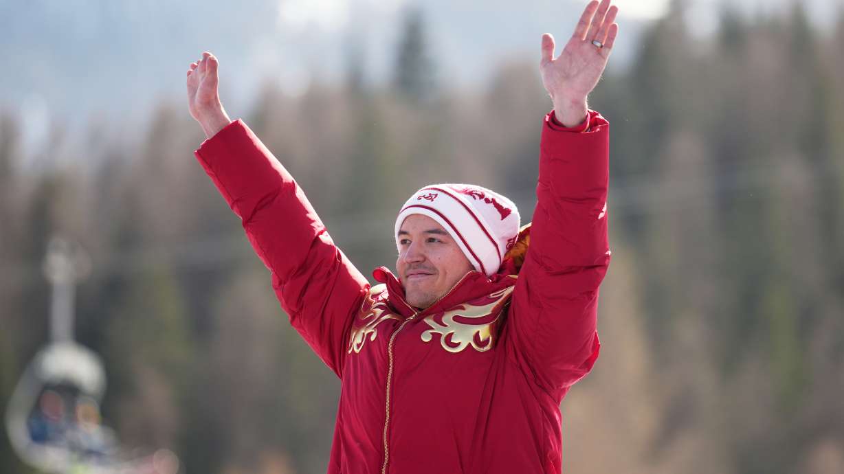 Aleksei Bugaev, of Russia, waves from the podium after winning the bronze medal in the alpine skiing men's downhill standing competition at the 2026 Winter Paralympics, in Cortina d'Ampezzo, Italy, Saturday, March 7, 2026.