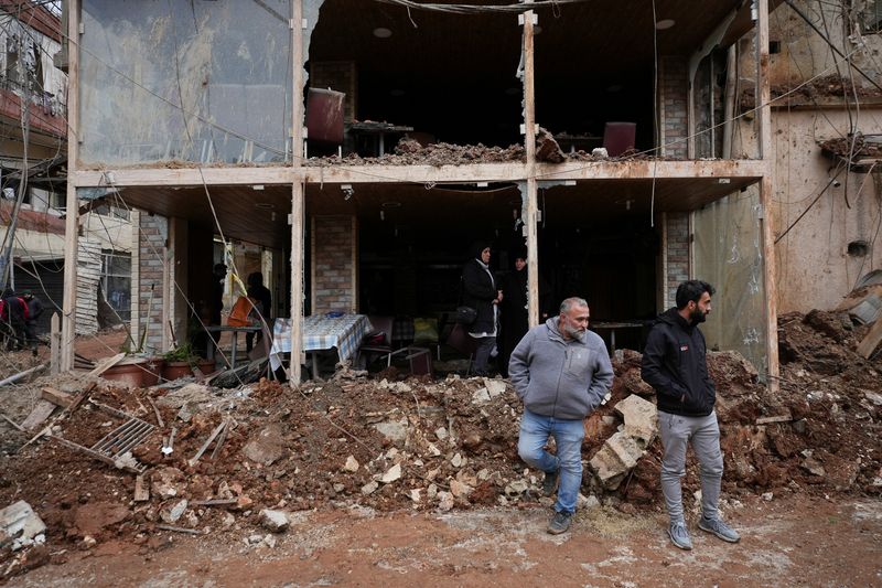 People inspect the damage where Israel's military carried out an airborne operation that dropped troops overnight in the town of Nabi Chit, Lebanon, Saturday. The death toll from the strikes has risen to 294 since Monday, the Lebanese health ministry said.