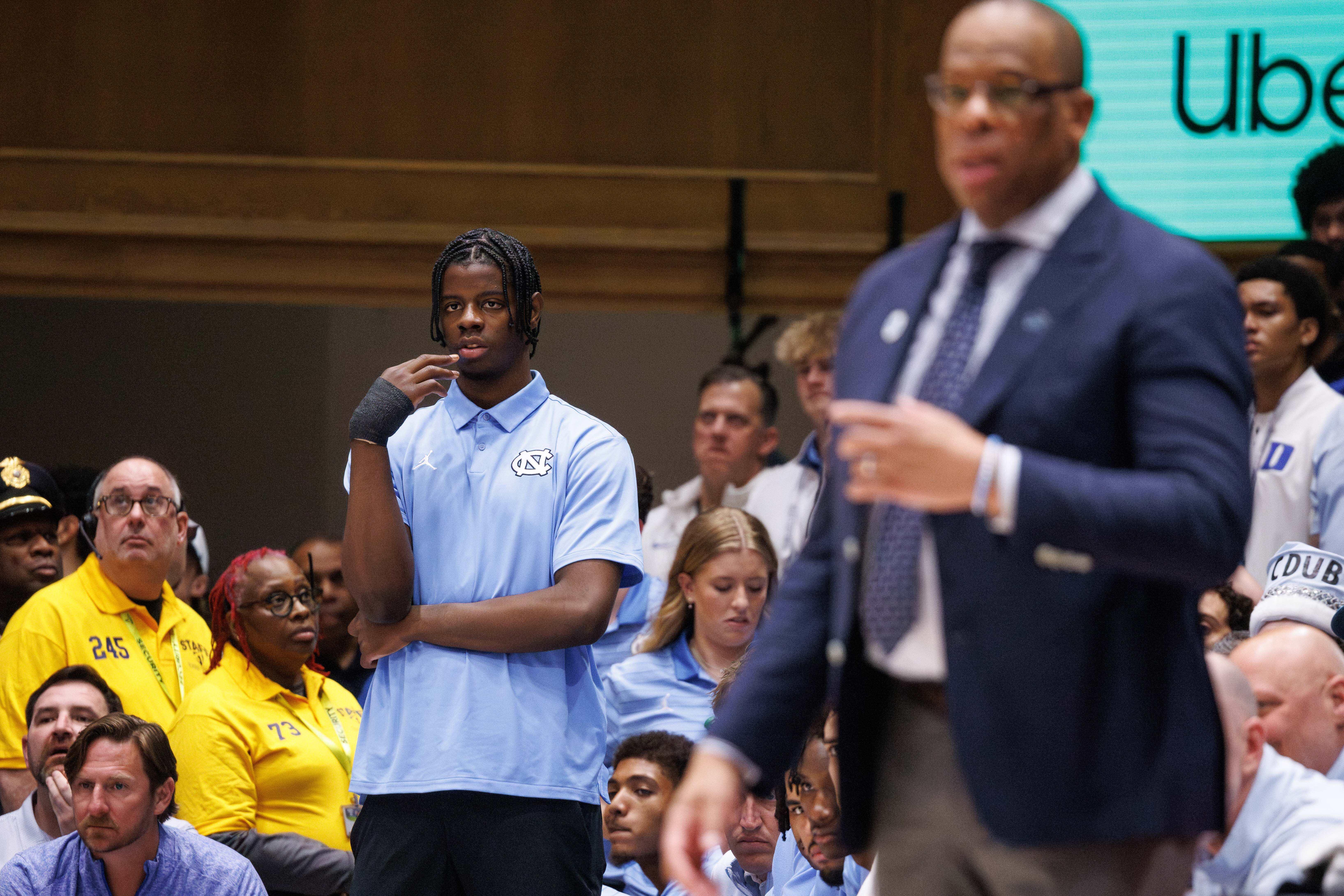 North Carolina's Caleb Wilson,left, who is injured, watches from the bench before an NCAA college basketball game against Duke in Durham, N.C., Saturday, March 7, 2026. 
