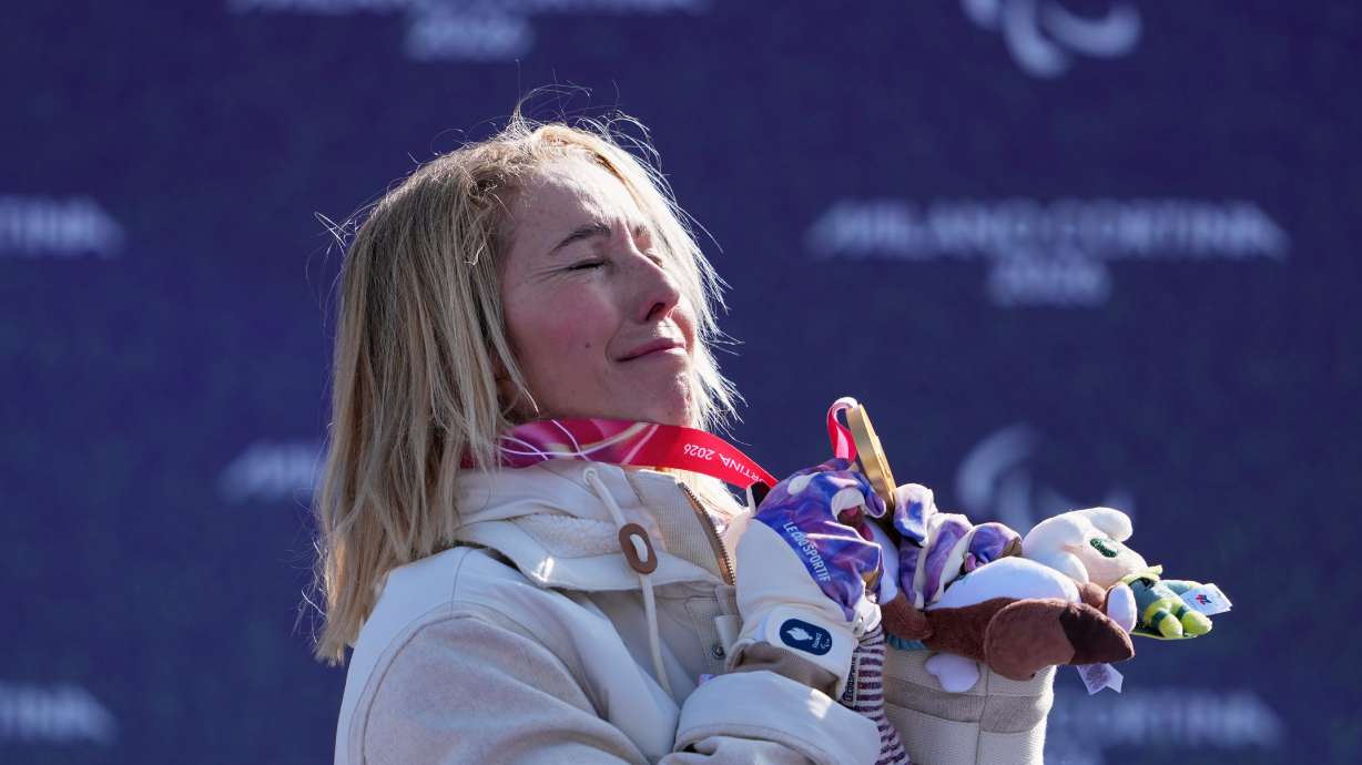 Cecile Hernandez, of France, stands on the podium after winning the gold medal in the women's snowboard cross SB-LL2 at the 2026 Winter Paralympics, in Cortina d'Ampezzo, Italy, Sunday, March 8, 2026. (AP Photo/Evgeniy Maloletka