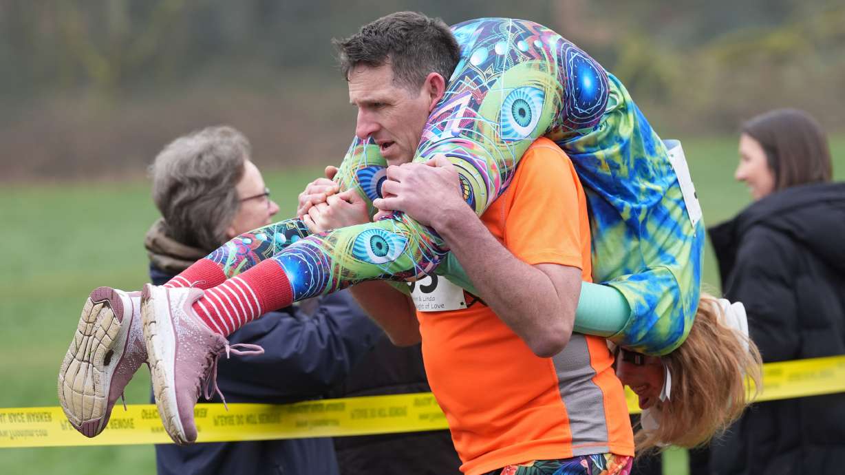 People take part in the annual UK Wife Carrying Race in Dorking, England, Sunday March 8, 2026.