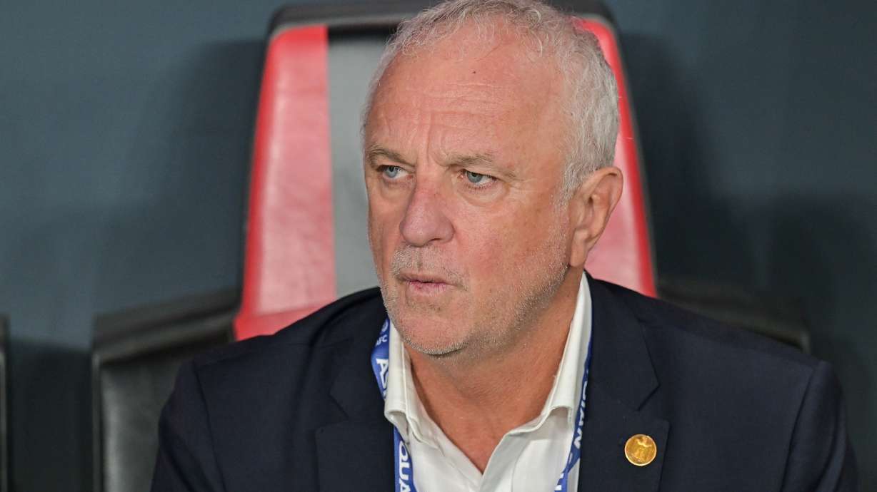 FILE- Iraqi's head coach Graham Arnold sits on the bench at the start of the 2026 World Cup play off first leg soccer match between UAE and Iraq in Abu Dhabi, United Arab Emirates, Friday, Nov. 14, 2025.