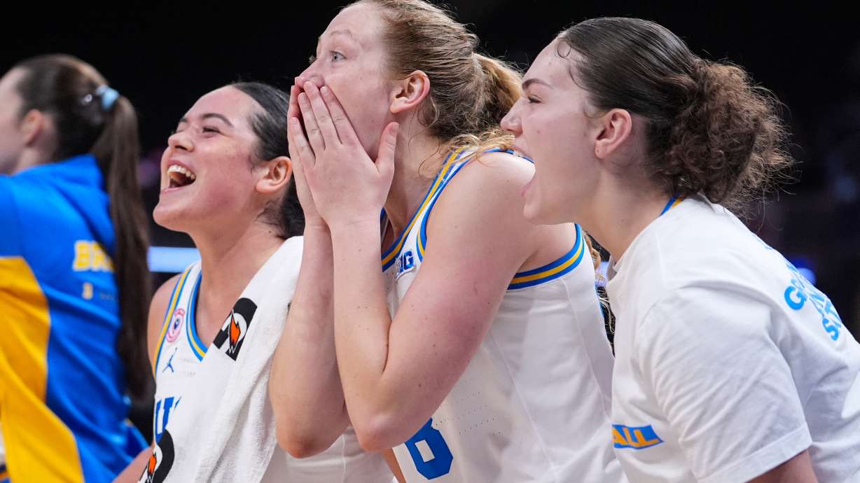 UCLA guard Charlisse Leger-Walker, left, guard Gianna Kneepkens, center, and guard Christina Karamouzi celebrate on the bench in the second half of an NCAA college basketball game in the finals of the Big Ten Conference tournament, Sunday, March 8, 2026 in Indianapolis.
