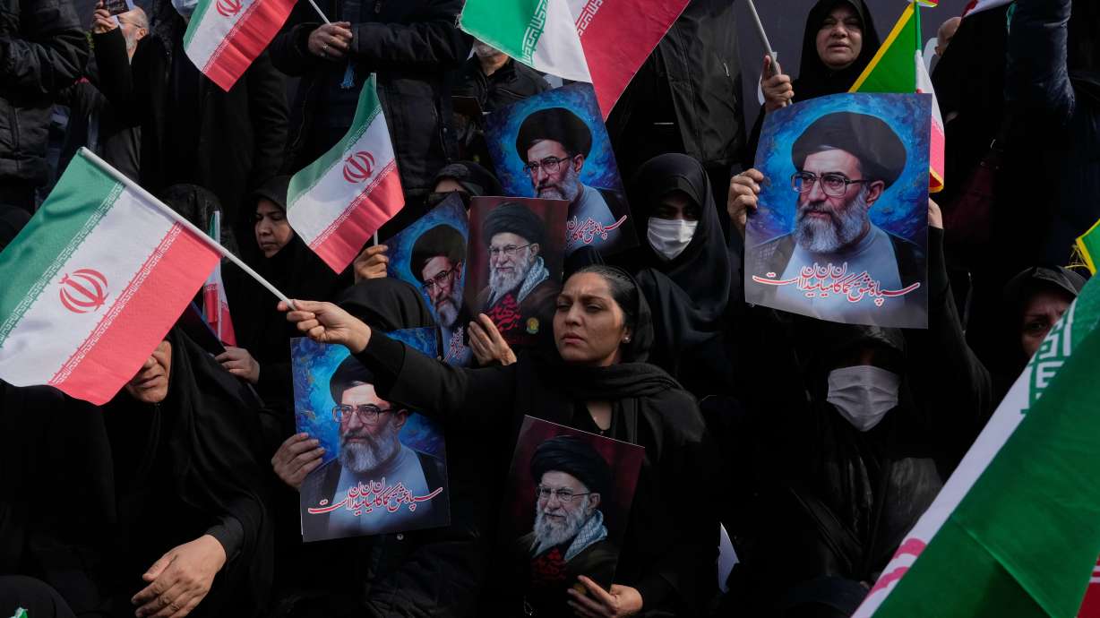 People wave Iranian flags as they hold posters of the late Supreme Leader Ayatollah Ali Khamenei during a rally to support his son Ayatollah Mojtaba Khamenei, who succeeds his father as the new supreme leader, in Tehran, Monday.