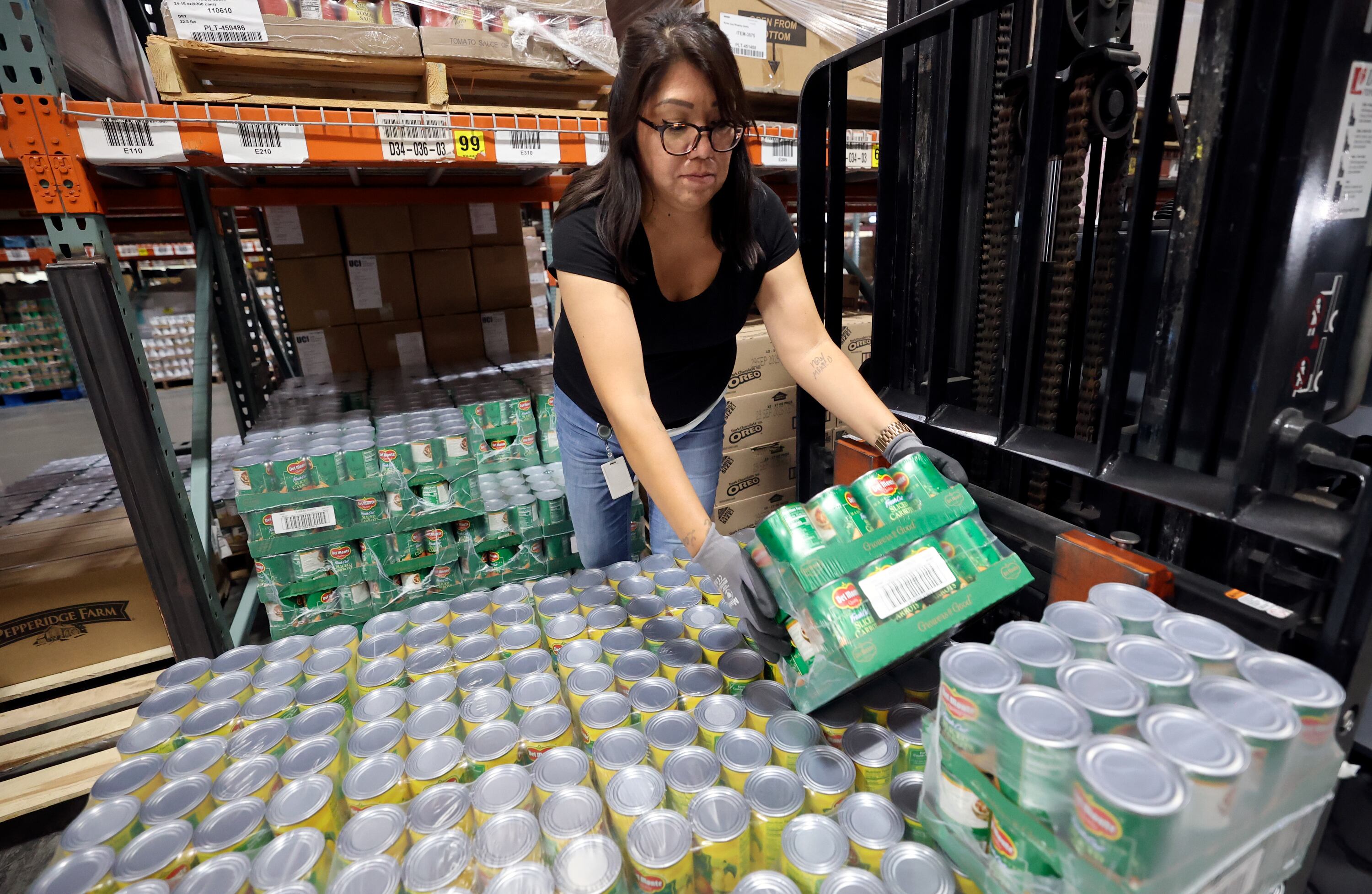 Kristin Chavez, Utah Food Bank warehouse associate, loads canned food onto a forklift at the Utah Food Bank in South Salt Lake on Oct. 27, 2025.