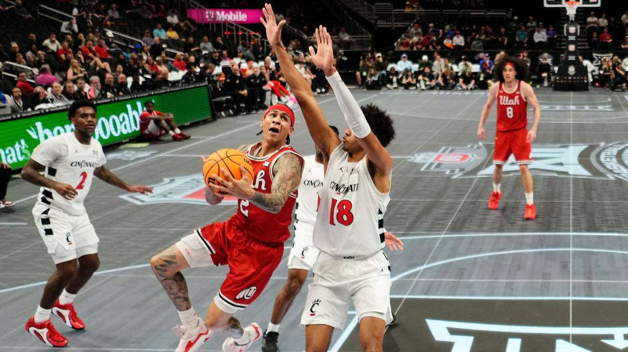Utah guard Terrence Brown (2) shoots under pressure from Cincinnati forward Baba Miller (18) during the first half of an NCAA college basketball game at the Big 12 Conference tournament Tuesday, March 10, 2026, in Kansas City, Mo.