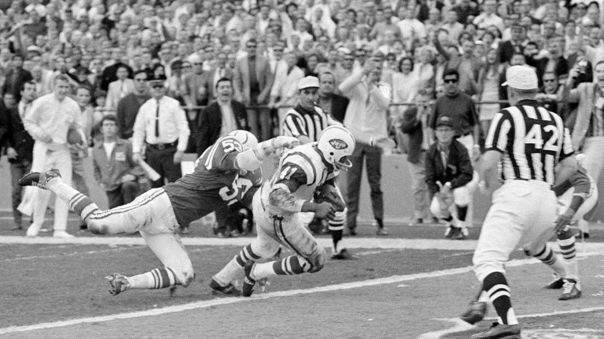 FILE - New York Jets fullback Matt Snell ,center, runs the ball as Baltimore linebacker Dennis Gaubatz, left, defends during the NFL football Super Bowl 3 in Miami, Jan. 12, 1969.