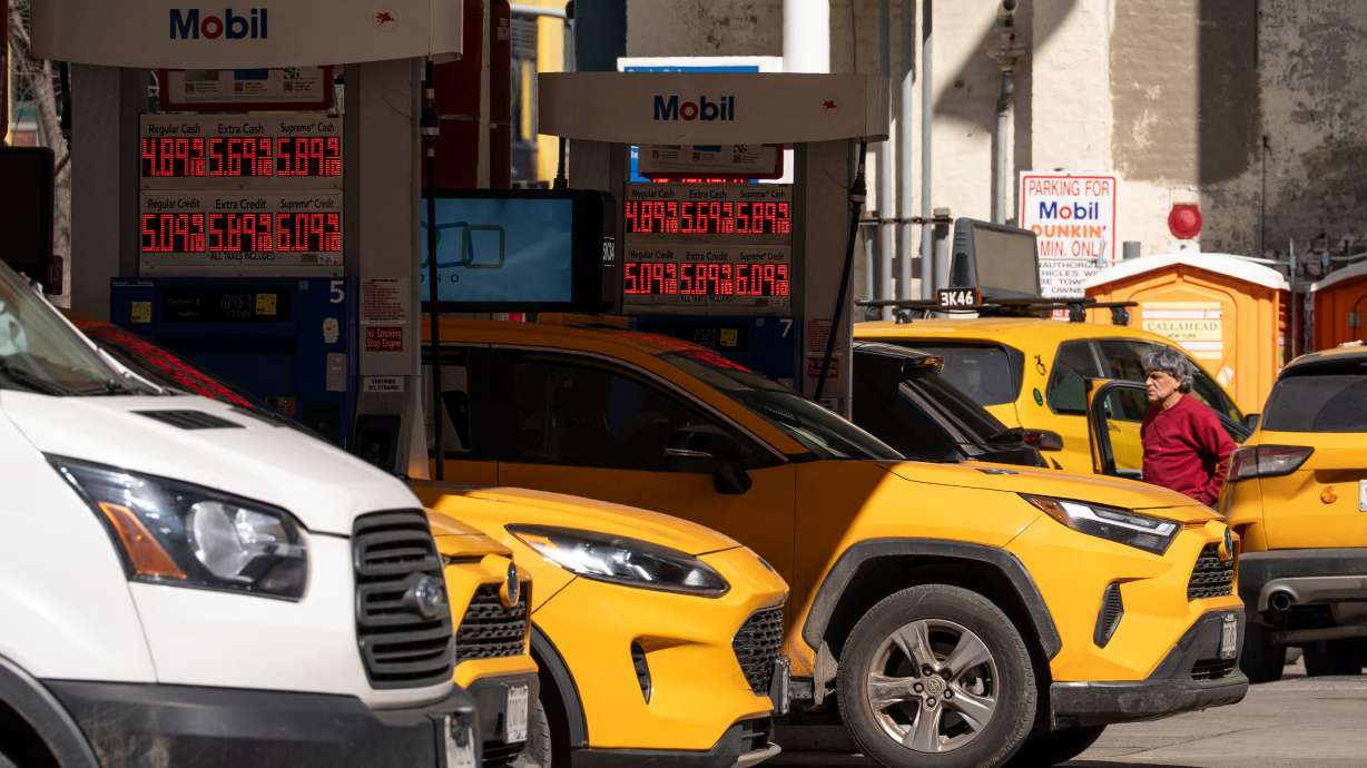 Signs show the gas prices at a gas station, Tuesday, in New York. The International Energy Agency agreed Wednesday to release the largest volume of emergency oil reserves in its history, in a bid to counter the effects on energy markets of the war in the Middle East.