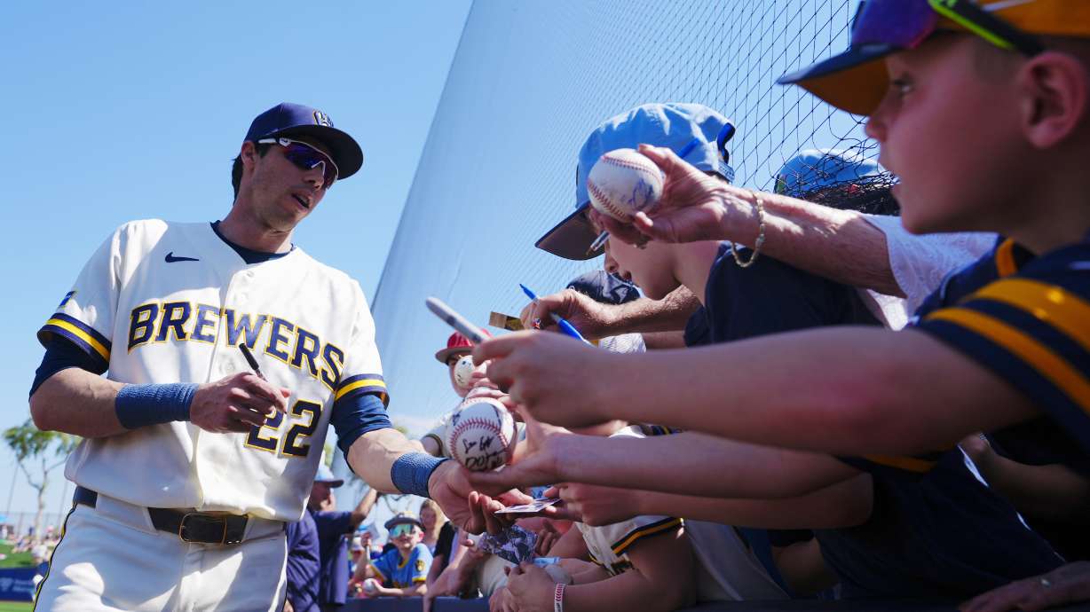 Milwaukee Brewers' Christian Yelich signs autographs prior to a spring training baseball game against the Los Angeles Dodgers Monday, March 9, 2026, in Phoenix.