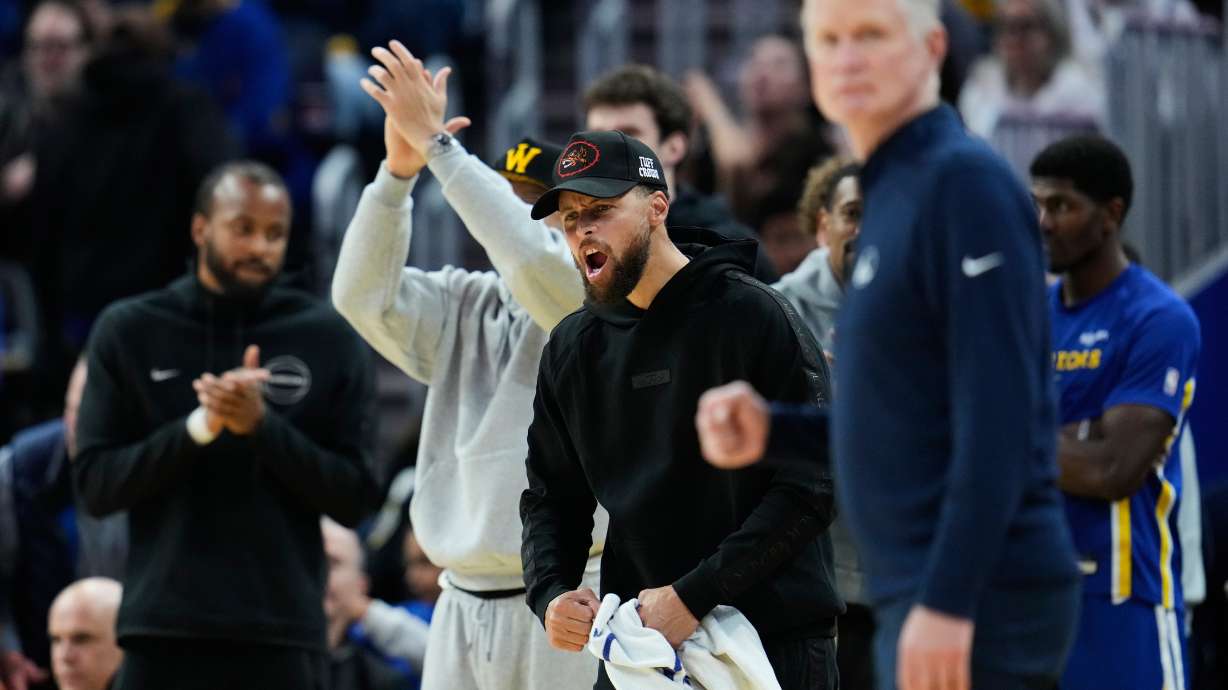 Golden State Warriors' Stephen Curry, center, reacts after his teammates scored during the second half of an NBA basketball game against the Chicago Bulls, Tuesday, March 10, 2026, in San Francisco.