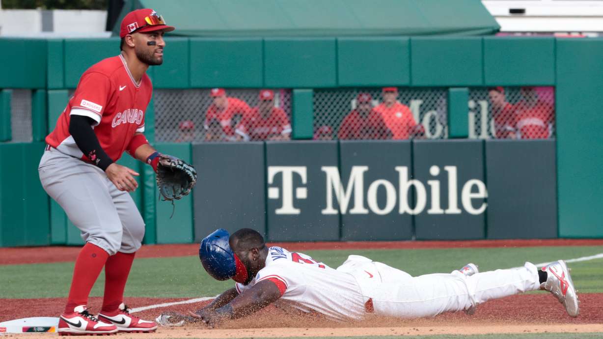 Cuba's Yoel Yanqui slides in safe at third base as Canada's Abraham Toro looks on during the fifth inning of a World Baseball Classic game in San Juan, Puerto Rico, Wednesday, March 11, 2026.