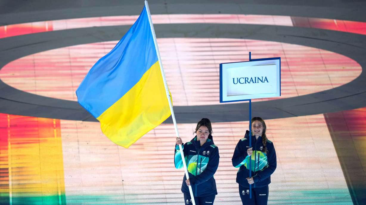 A volunteer holds the Ukrainian flag to take part in the opening ceremony at the 2026 Winter Paralympics, in Verona, Italy, Friday, March 6, 2026.