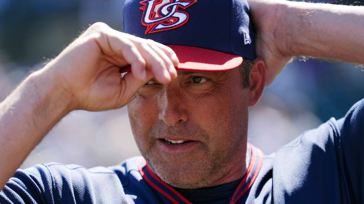 United States manager Mark DeRosa adjusts his baseball cap prior to an exhibition baseball game against the Colorado Rockies Wednesday, March 4, 2026, in Scottsdale, Ariz.