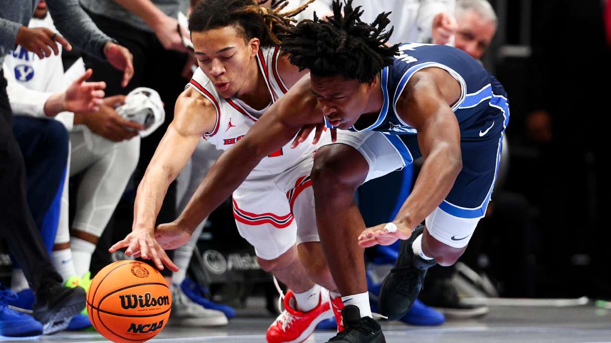 Houston Cougars guard Kingston Flemings (4) and BYU guard Robert Wright III (1) dive for a loose ball during the first half of the quarterfinal of the 2026 Phillips 66 Big 12 Men's Basketball Tournament at the T-Mobile Center in Kansas City, Missouri, on Thursday, March 12, 2026.