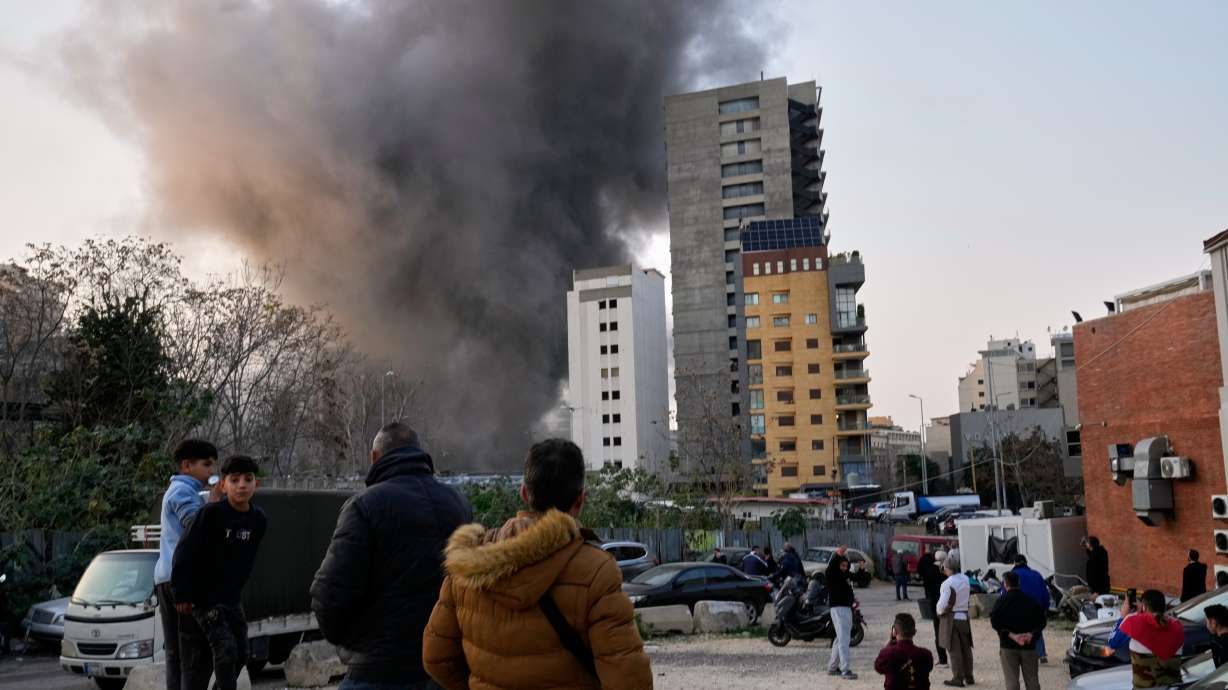 Residents watch as smoke rises from a nearby building during an Israeli strike in central Beirut, Lebanon, Thursday.