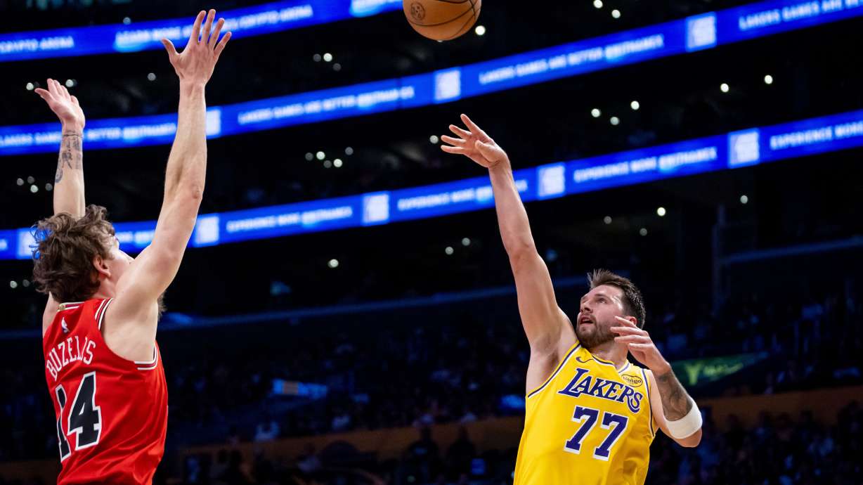 Los Angeles Lakers guard Luka Doncic (77) shoots against Chicago Bulls forward Matas Buzelis (14) during the first half of an NBA basketball game against the Chicago Bulls, Thursday, March 12, 2026, in Los Angeles.
