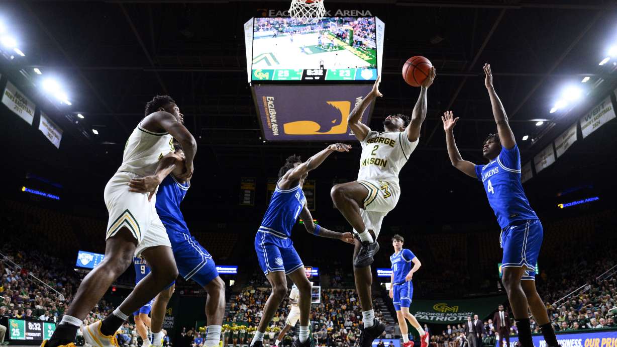 George Mason guard Jahari Long (2) goes to the basket past Saint Louis guard Amari McCottry (4) during the first half of an NCAA college basketball game, Saturday, March 7, 2026, in Fairfax, Va.