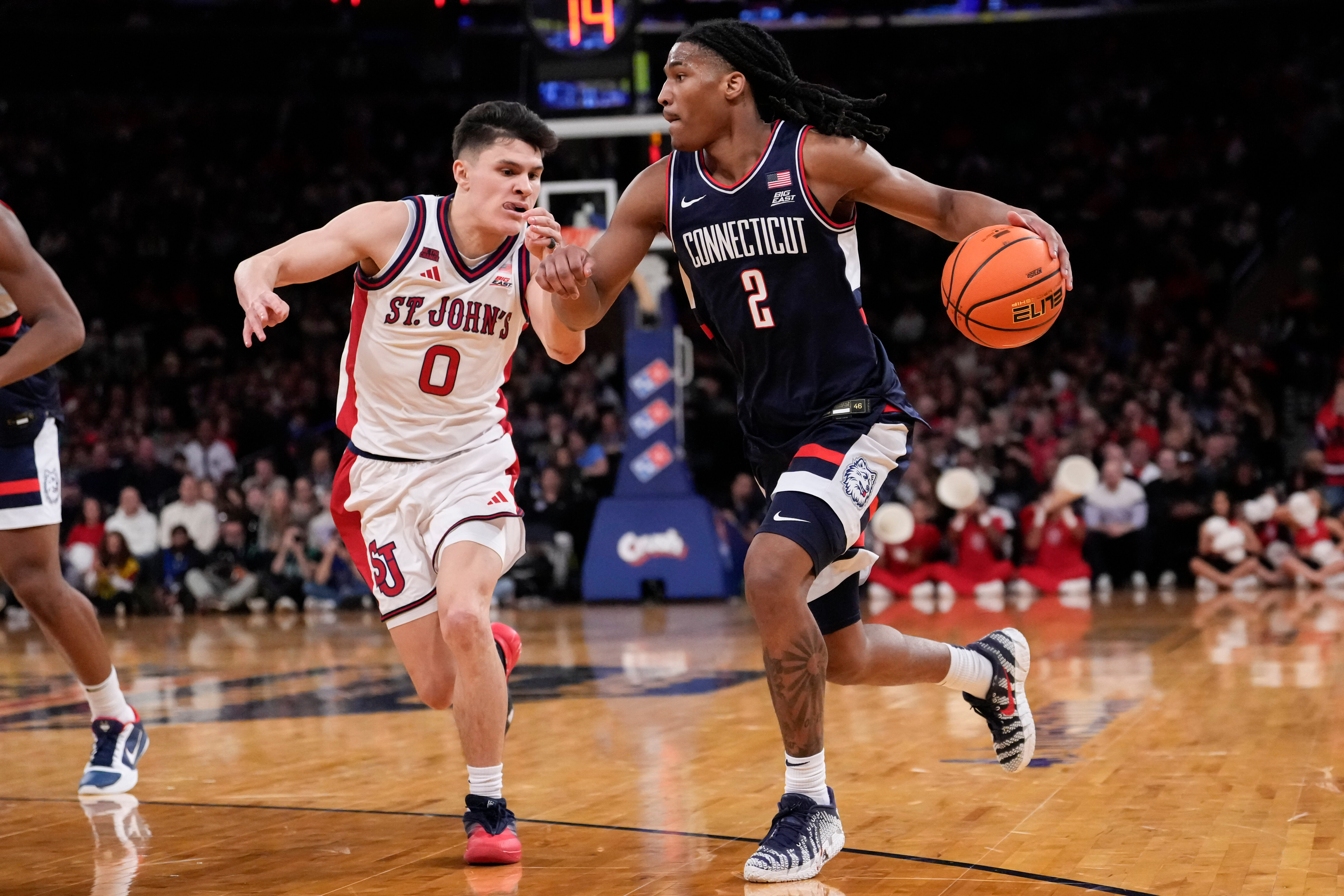 UConn guard Silas Demary Jr. (2) drives past St. John's guard Dylan Darling (0) during the half of an NCAA college basketball game in the championship of the Big East tournament, Saturday, March 14, 2026, in New York. 