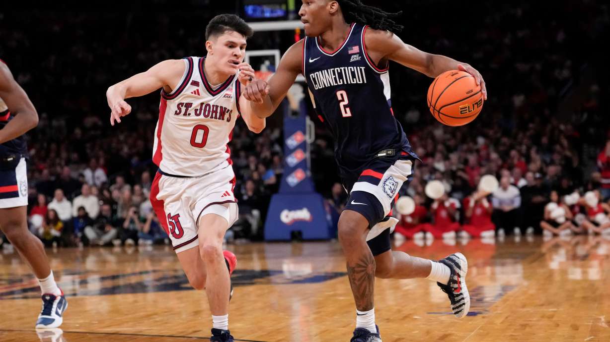 UConn guard Silas Demary Jr. (2) drives past St. John's guard Dylan Darling (0) during the half of an NCAA college basketball game in the championship of the Big East tournament, Saturday, March 14, 2026, in New York.