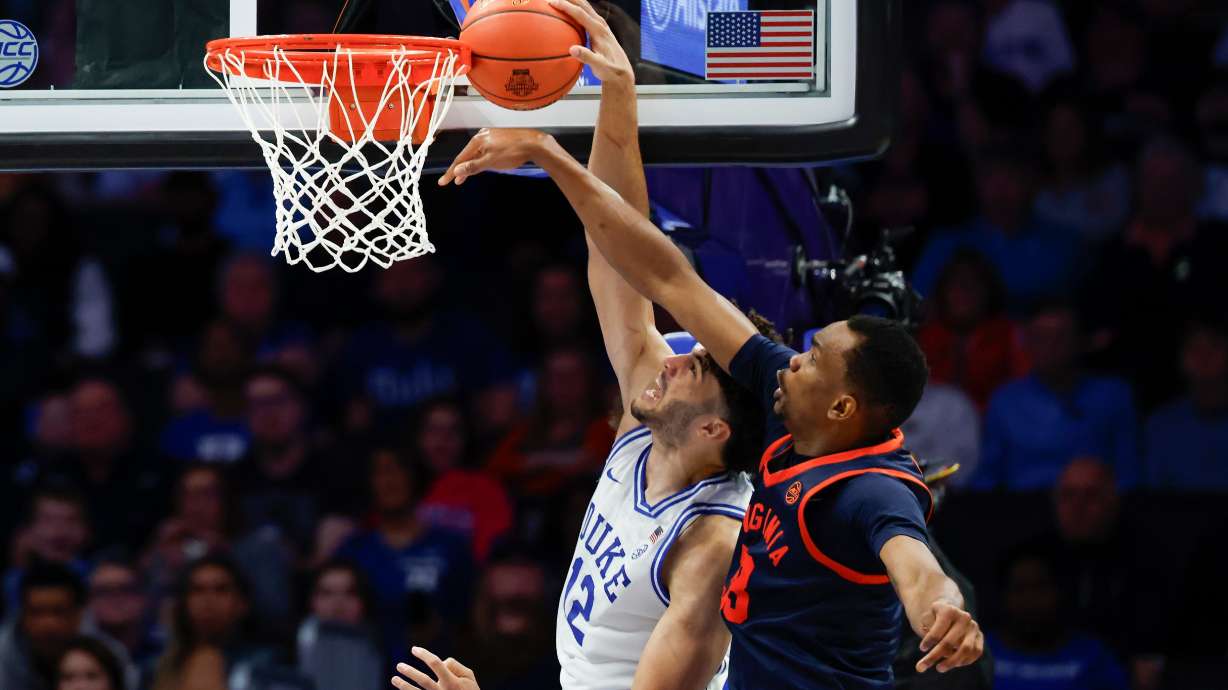 Virginia center Ugonna Onyenso, right, alters shot by Duke forward Cameron Boozer during the second half of an NCAA college basketball game in the championship of the Atlantic Coast Conference tournament in Charlotte, N.C., Saturday, March 14, 2026.