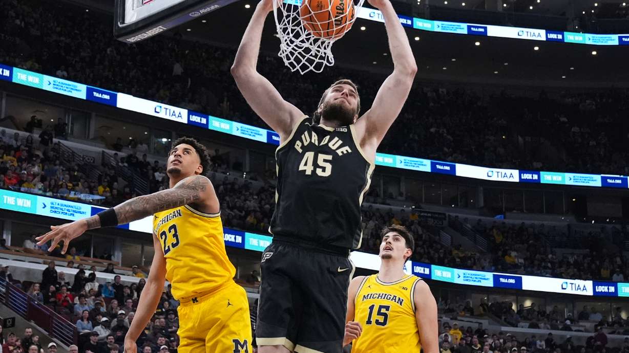 Purdue center Oscar Cluff (45) dunks past Michigan forward Yaxel Lendeborg (23) during the first half of an NCAA college basketball game in the championship of the Big 10 Conference tournament, Sunday, March 15, 2026, in Chicago.