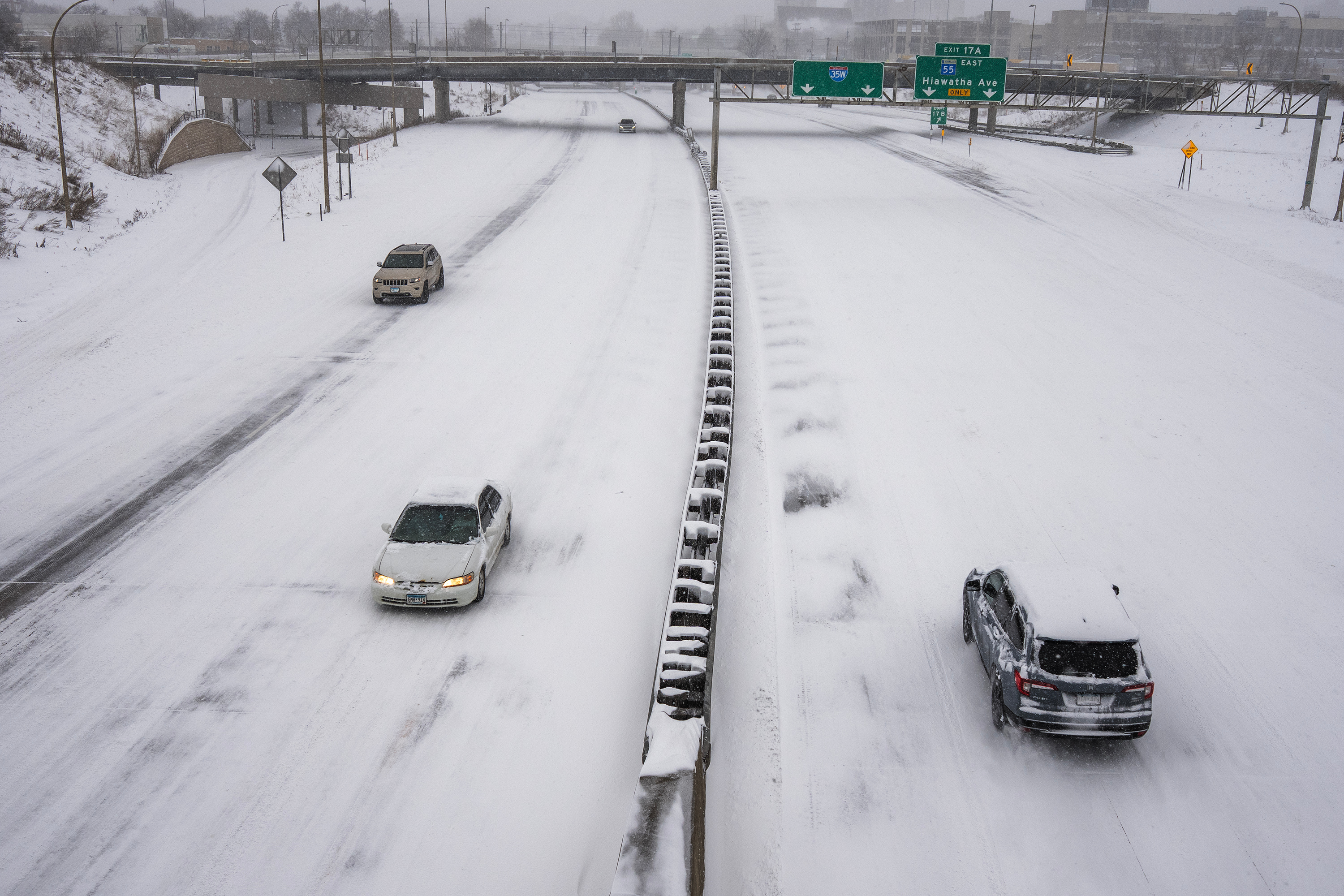 People drive on a snow-covered freeway during a snowstorm, Sunday, in Minneapolis.
