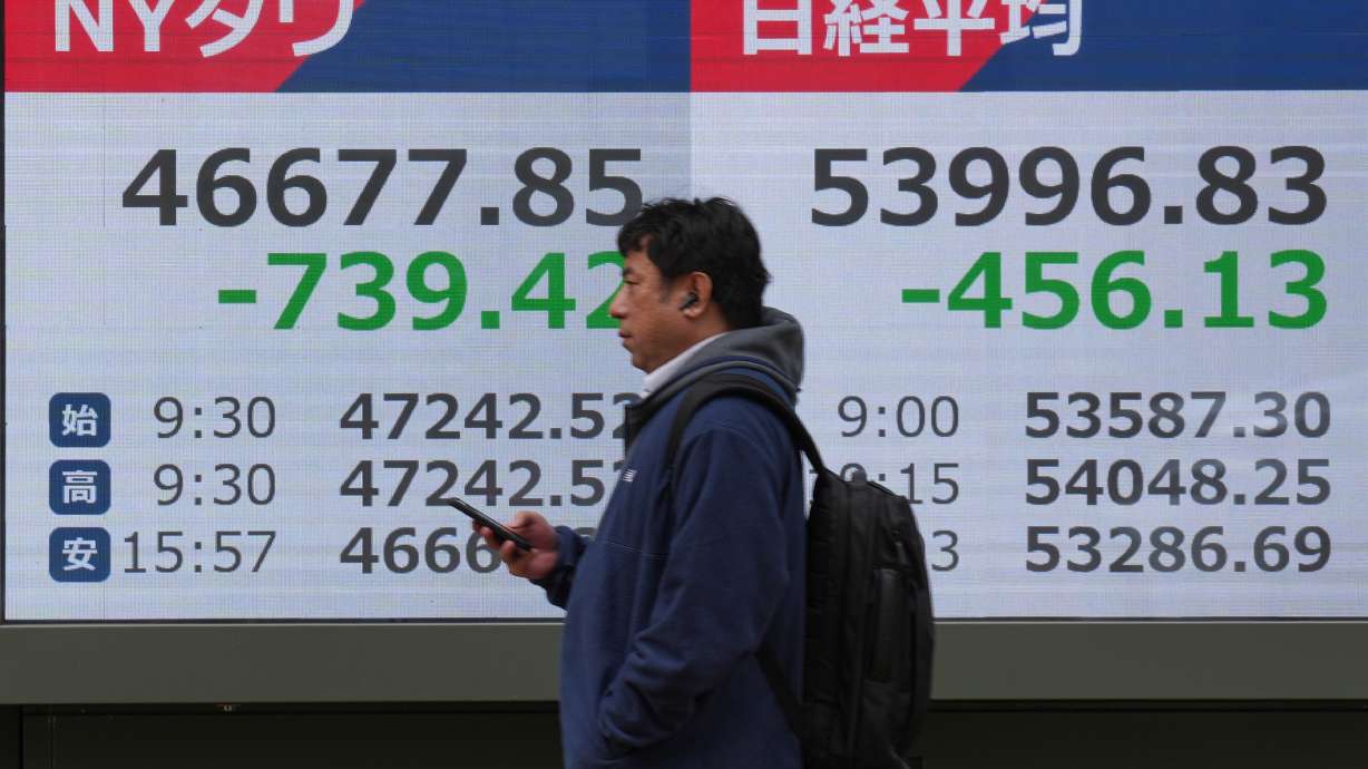 A person walks in front of an electronic stock board showing Japan's Nikkei index at a securities firm on Friday in Tokyo.