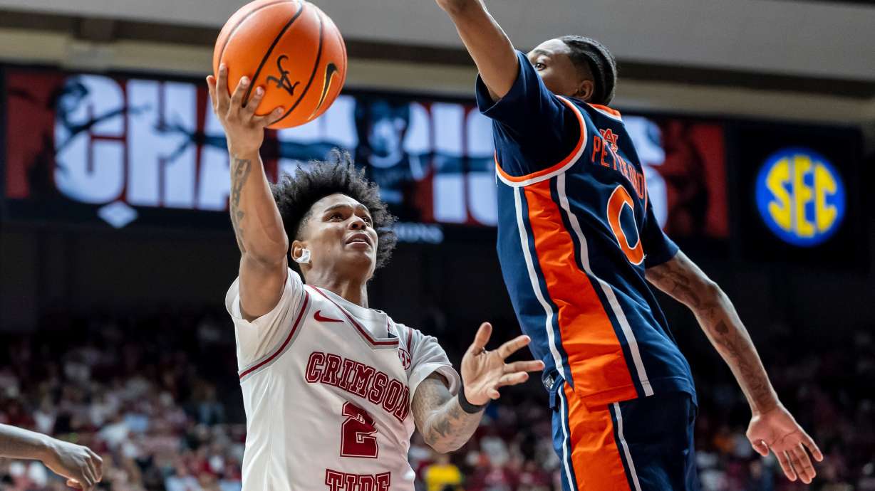 Alabama guard Aden Holloway (2) looks to shoot past Auburn guard Tahaad Pettiford (0) during the second half of an NCAA college basketball game Saturday, March 7, 2026, in Tuscaloosa, Ala.