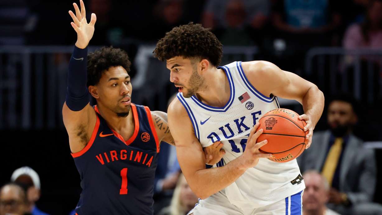 Duke forward Cameron Boozer, right, looks to drive against Virginia guard Malik Thomas (1) during the second half of an NCAA college basketball game in the championship of the Atlantic Coast Conference tournament in Charlotte, N.C., Saturday, March 14, 2026.