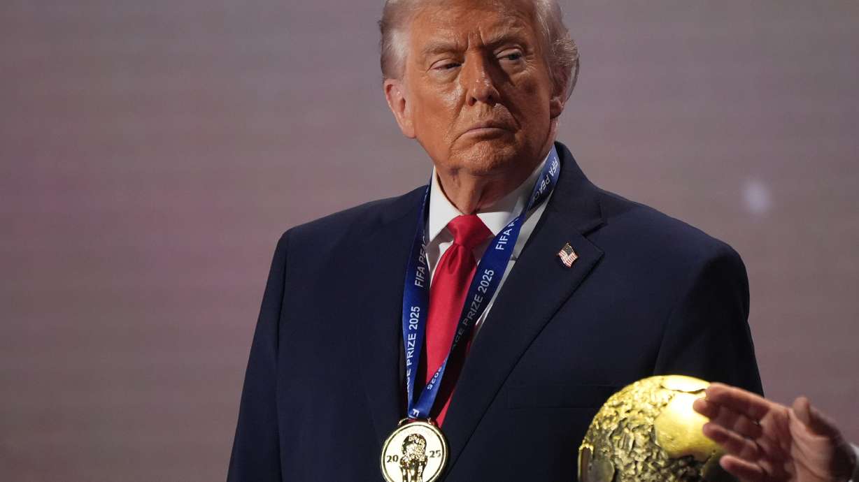 FILE - President Donald Trump stands on stage next to the FIFA World Cup after receiving the FIFA Peace Prize during the draw for the 2026 soccer World Cup at the Kennedy Center in Washington, Dec. 5, 2025.