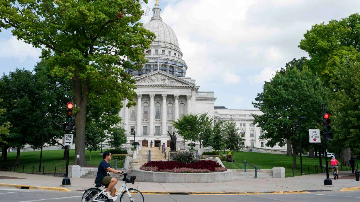 FILE - A cyclist rides past the Wisconsin State Capitol on July 30, 2024, in Madison, Wis.