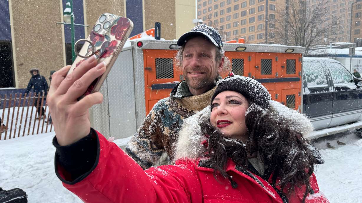 Defending Iditarod Trail Sled Dog Race champion Jessie Holmes poses for a selfie with a fan during the ceremonial start of this year's race in downtown Anchorage, Alaska, on Saturday, March 7, 2026.