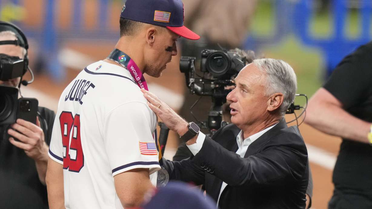 MLB Commissioner Rob Manfred talks to United States right fielder Aaron Judge (99) during the awards ceremony following the championship game of the World Baseball Classic against Venezuela, Tuesday, March 17, 2026, in Miami.